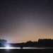 Tranquil night sky view over Polish landscape with stars and distant lights.
